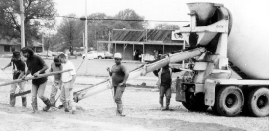 Workers using concrete truck.