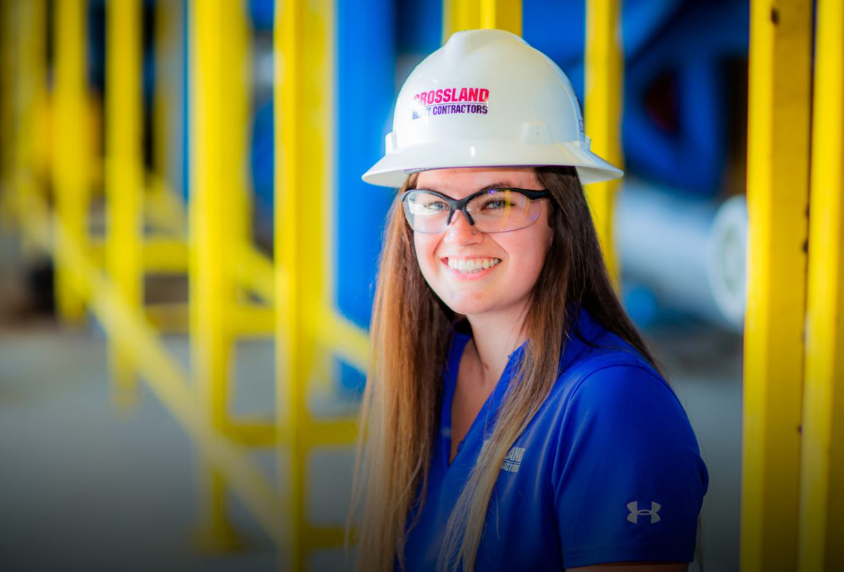 Crossland Construction employee wearing hardhat in warehouse.