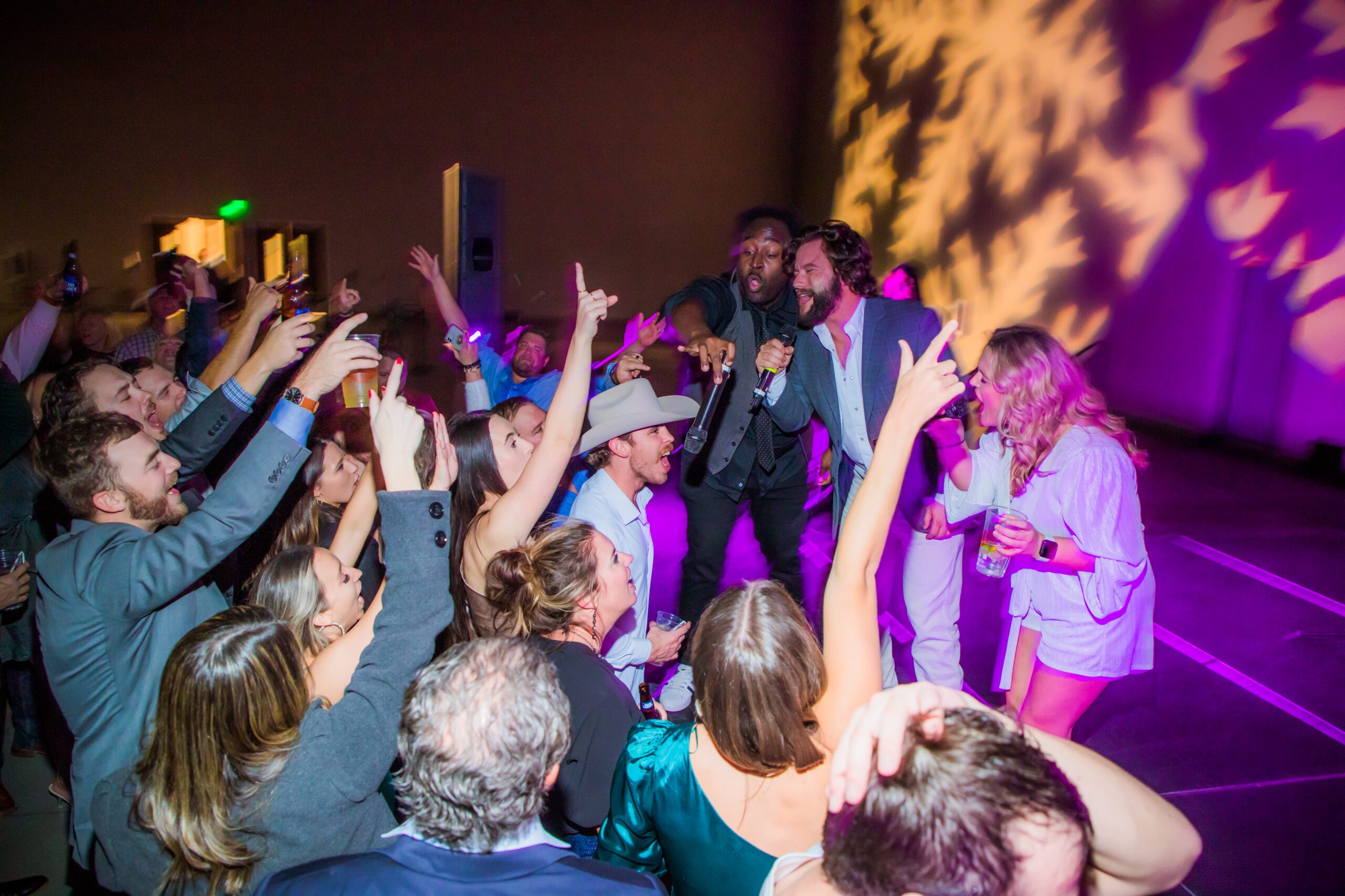 A group of people at a concert venue engaging a group on stage.