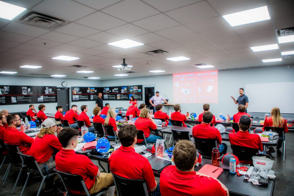 A group of people in red shirts in a classroom.