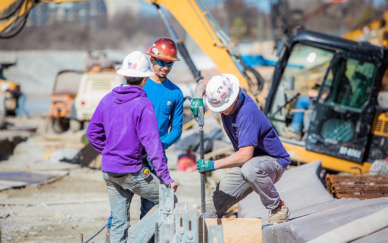 Three construction workers working at a construction site.