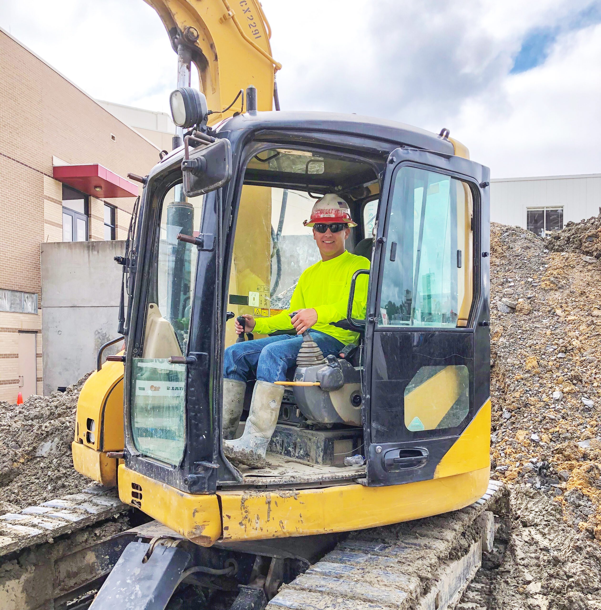 A man sitting in a yellow excavator.