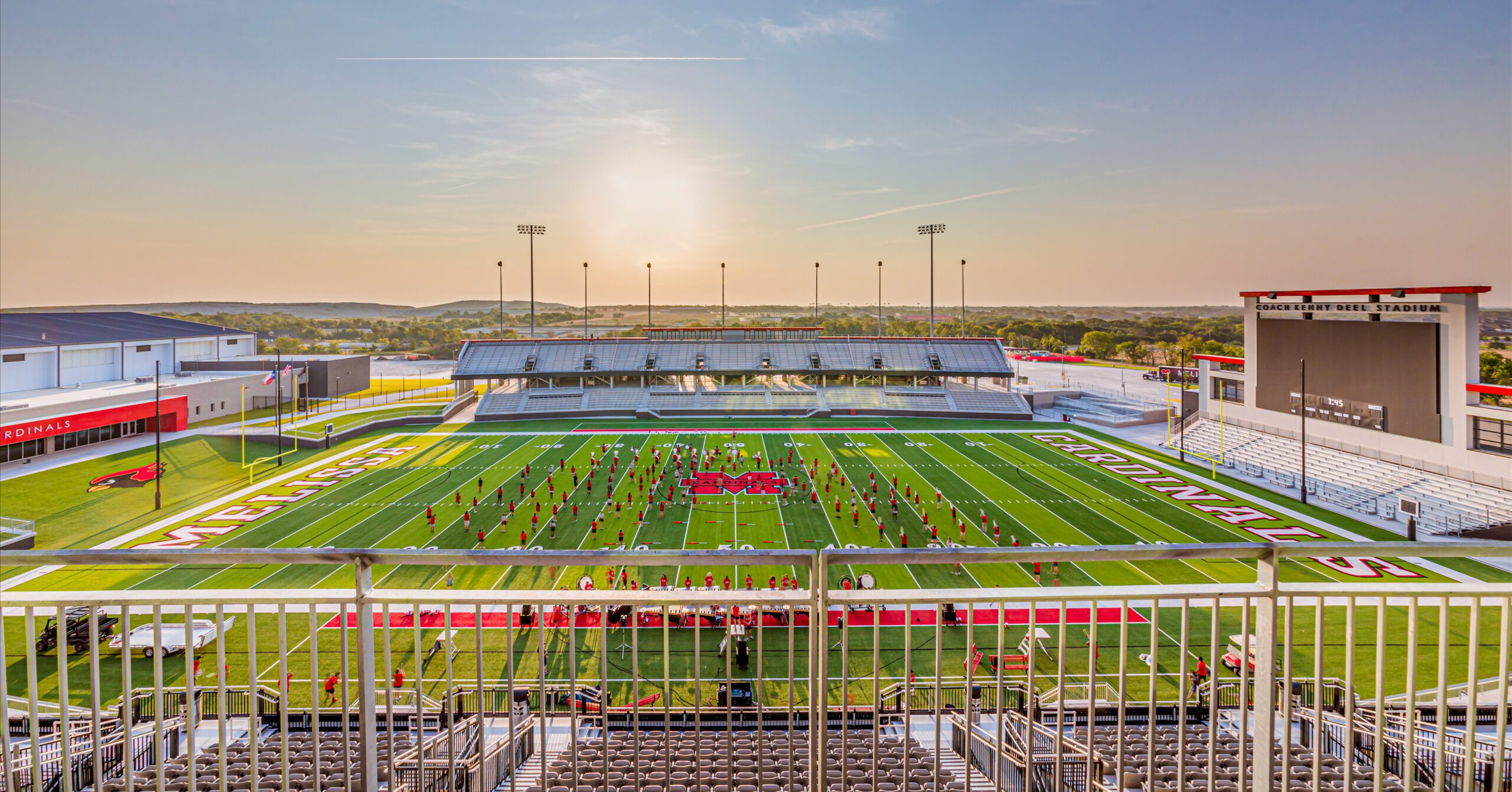 A view of a football field with a stadium in the background.