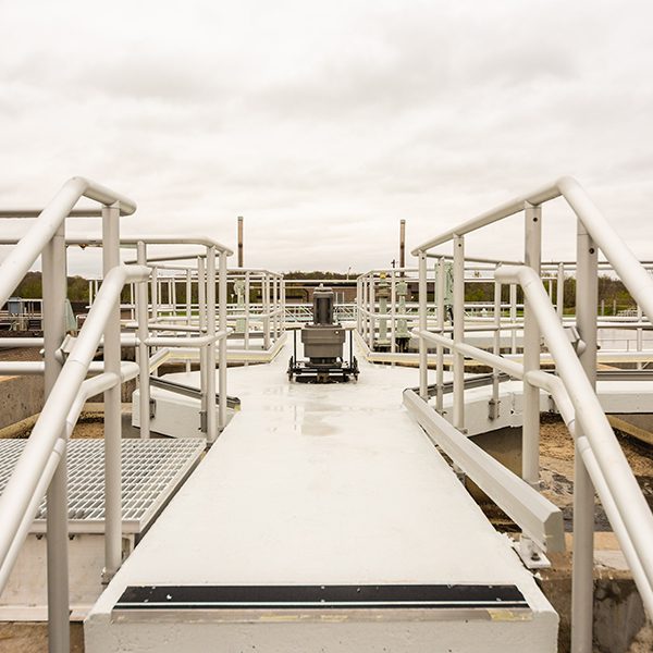 A metal walkway leading to a water treatment plant.