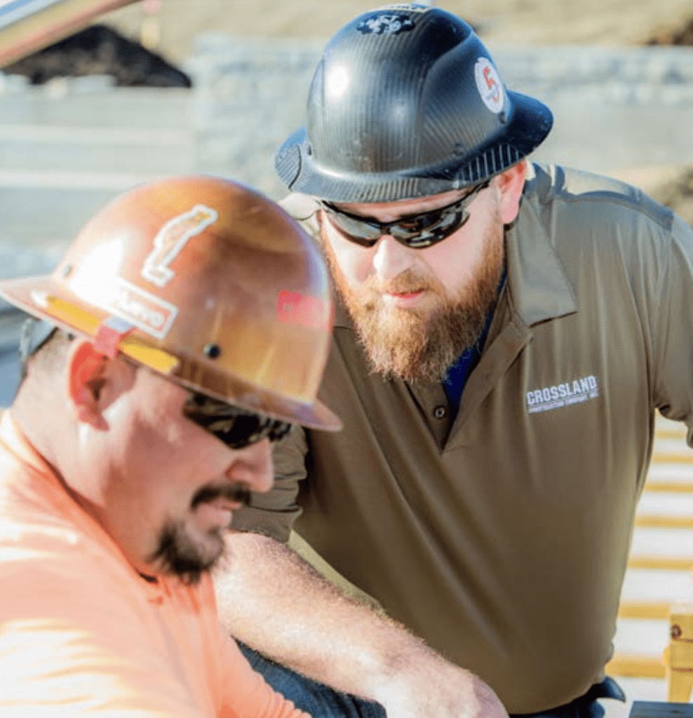Two men in hard hats working on a construction project.