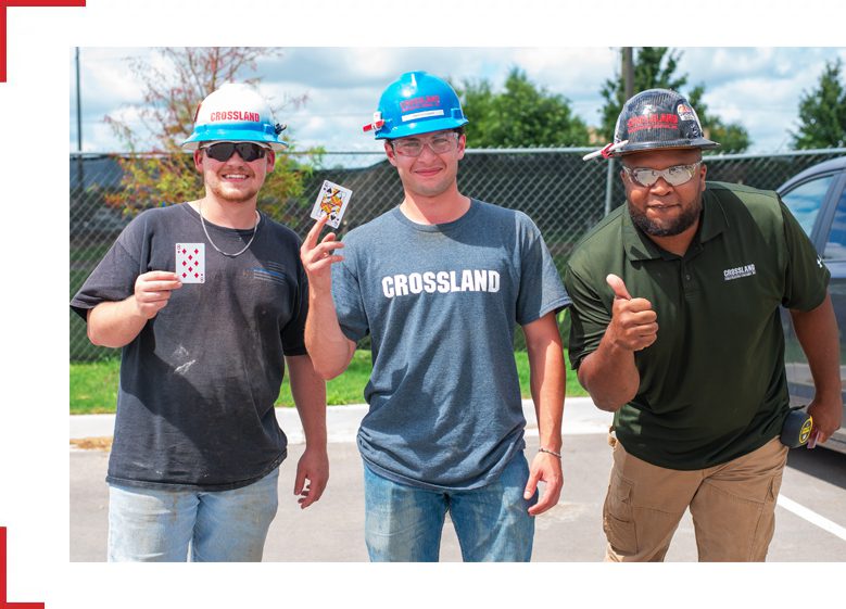 Three men in hard hats standing next to each other.