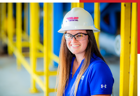 Crossland Construction employee wearing hardhat in warehouse.