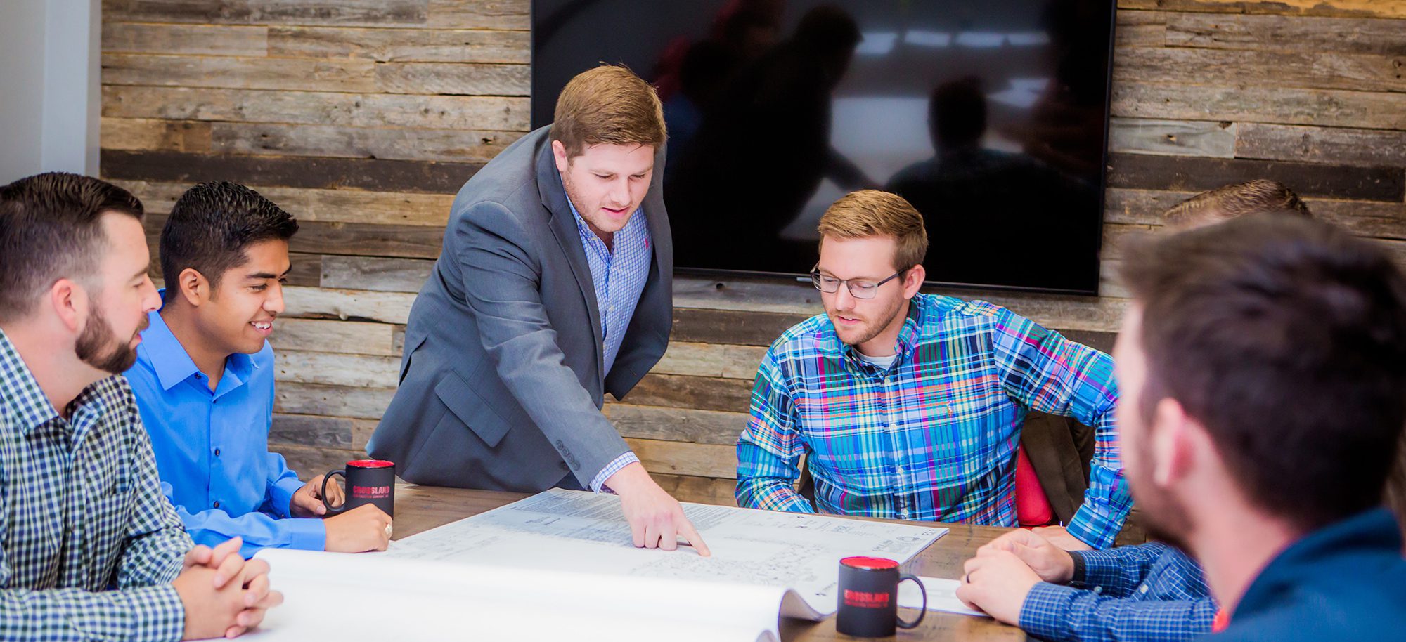 Three business men having meeting around board table.