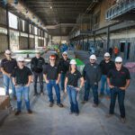 A group of people in hard hats standing in a building under construction.