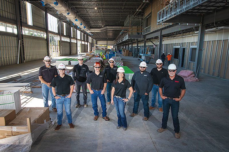 A group of people in hard hats standing in a building under construction.